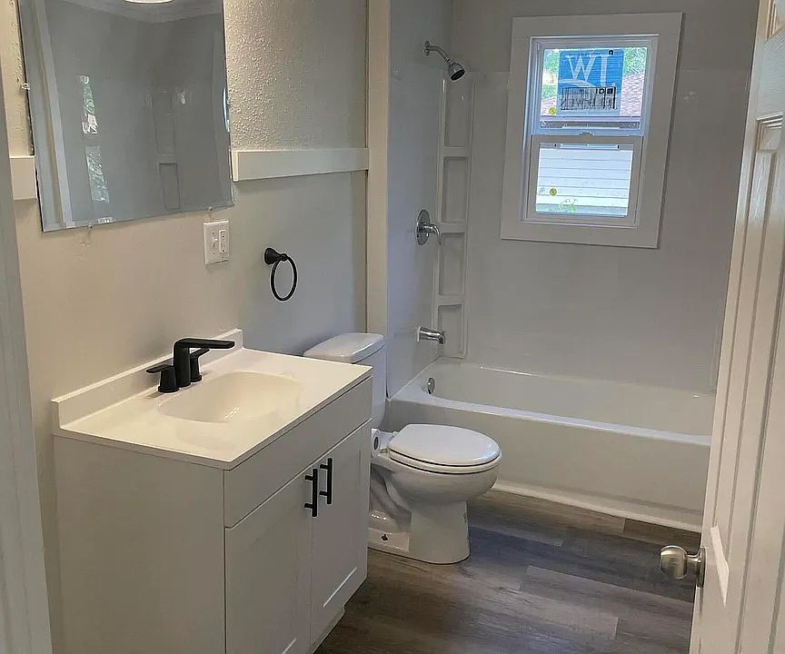 Bathroom with newer vanity, toilet, and shower.
