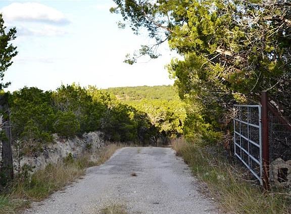 Gated entrance to paved driveway leading to the home with hilltop location