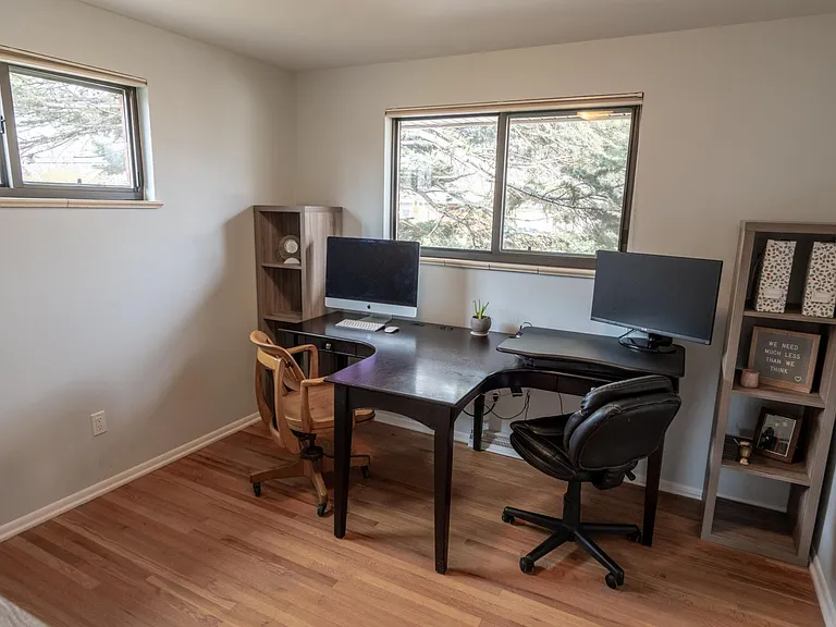 View from the entry door to the north-east bedroom. The room has two windows, facing north and east and a built-in closet.
