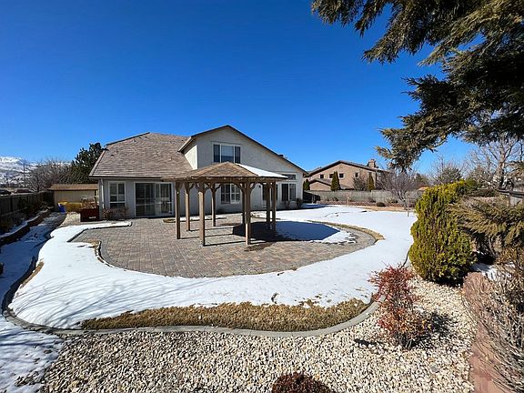 Spacious fenced-in backyard with gazebo and pavers.