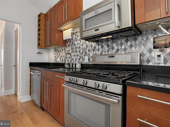 Kitchen with wooden built-in wine racks, full backsplash, iPad/iphone holder under cabinets, stainless appliances, great cabinets and storage