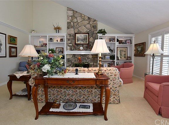 Modern custom shelving w/lighting. Custom woodwork, beautiful stone fireplace and plantation shutters.