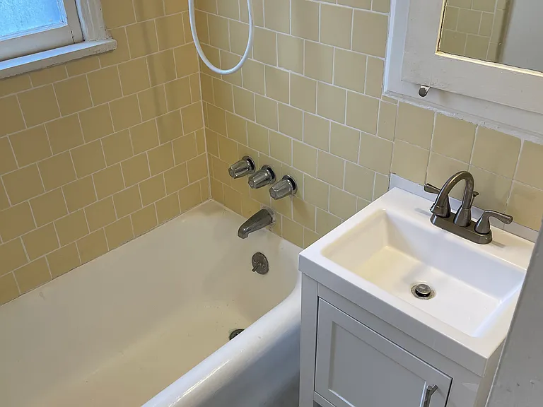 203 Bathroom has tub/shower combo and newer vanity, lighting and hardware