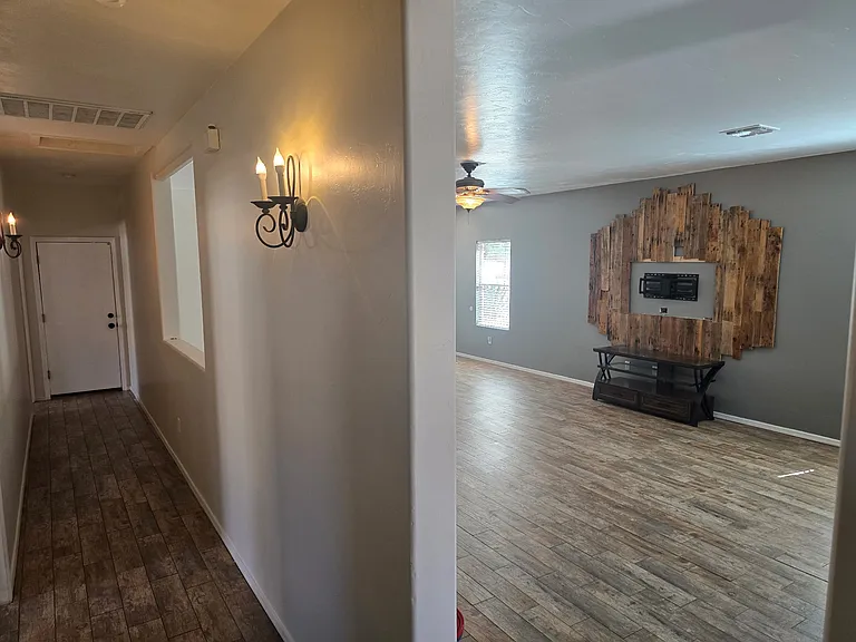View of the hallway and living room. Entertainment center not included