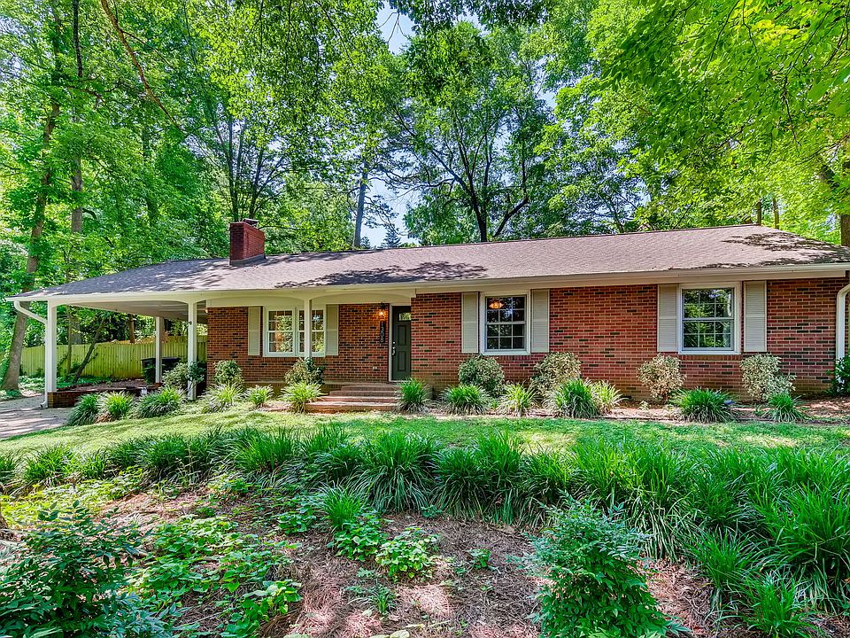 Lush, mature trees and landscape. Sloped front yard. Home is tucked away perched above Forest Park Dr.