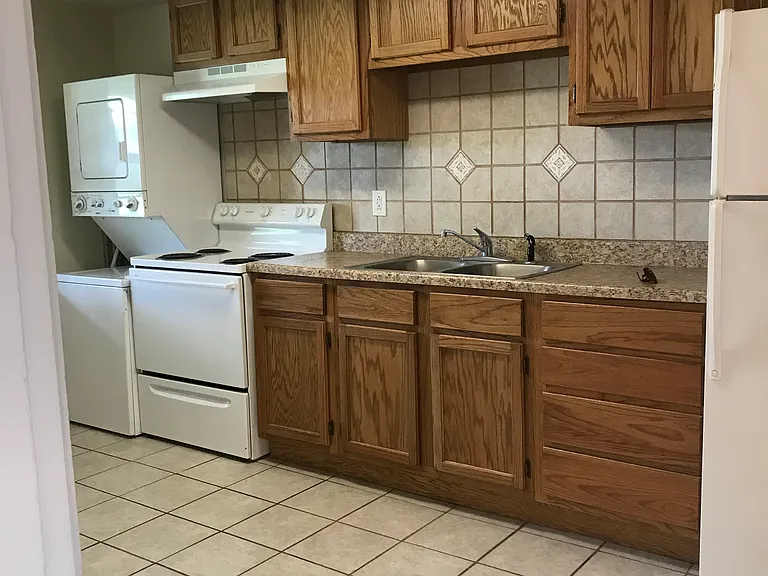 Kitchen, viewed from living room, full sized appliances, includes washer/dryer stack unit.