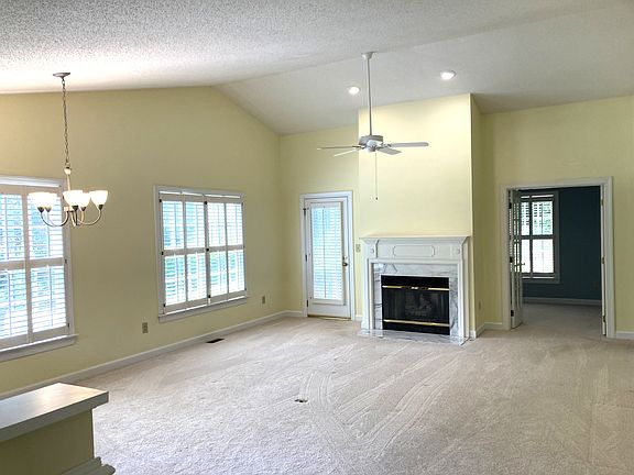Spacious living room features fireplace and vaulted ceiling