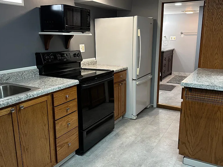 Newer refrigerator and new LVT flooring in kitchen and bathroom