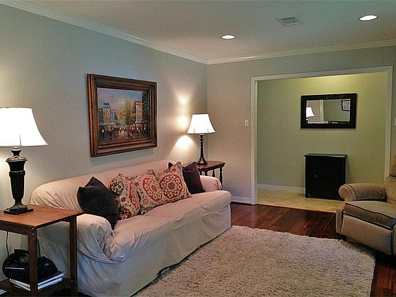 The formal living room has a hardwood floor, crown molding and recessed lighting.