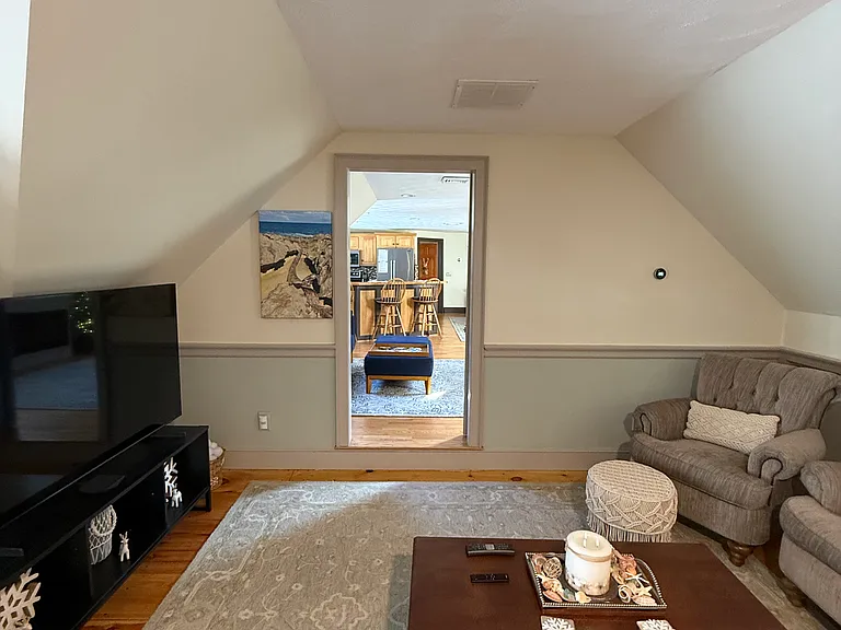 Living room with view into seating kitchen and dining room