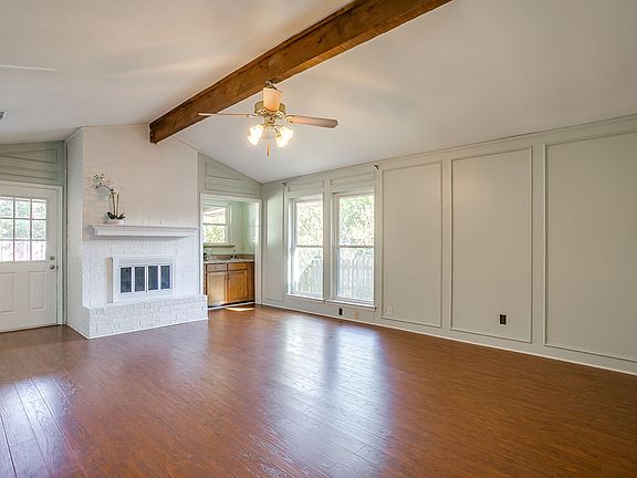 Living room with fireplace, ceiling beam with a wet bar.