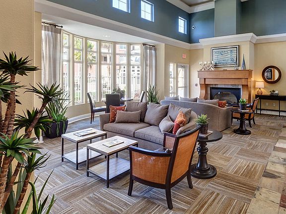 Club room with couches, a fireplace, and large windows.