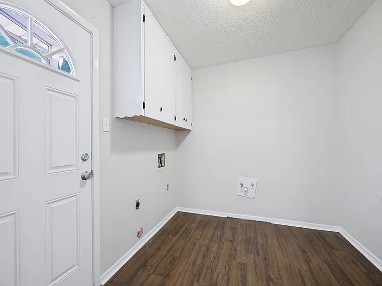 Oversized laundry room has space for a full washer and dryer and additional storage.