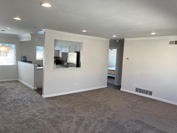View from the Living Room facing the Kitchen. The Dining Room is to the left. Bedroom 2 can be seen (located to the right of the Kitchen).