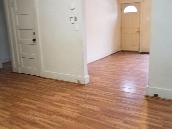 dining room looking into living room. To left is bathroom and front bedroom and door to basement.