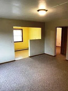 view across living room to kitchen showing space in kitchen for table.