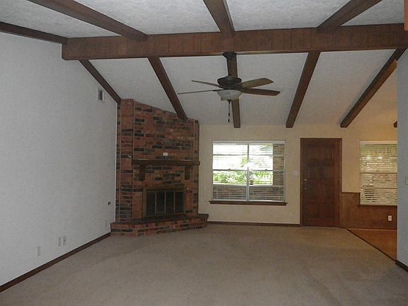 Wood burning fireplace is seen as you wall in.
