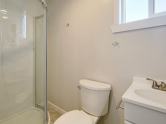 Full bathroom with shower, sink, traditional toilet and stor