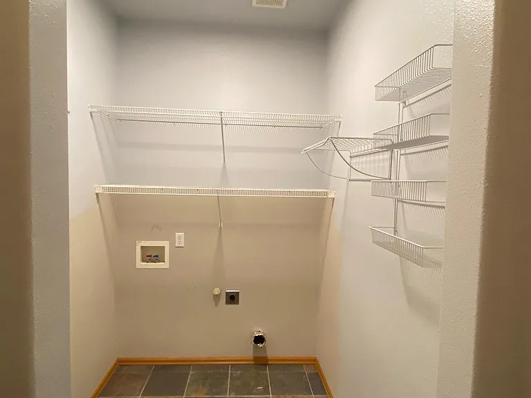 there are now high-efficiency washer and dryer in this space. On the opposite wall is the door to the garage.