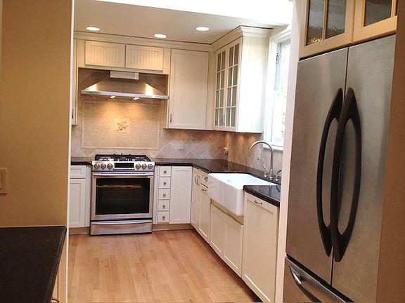 Chef's kitchen with granite countertops, farmhouse sink, stainless gas stove/oven and stainless refrigerator