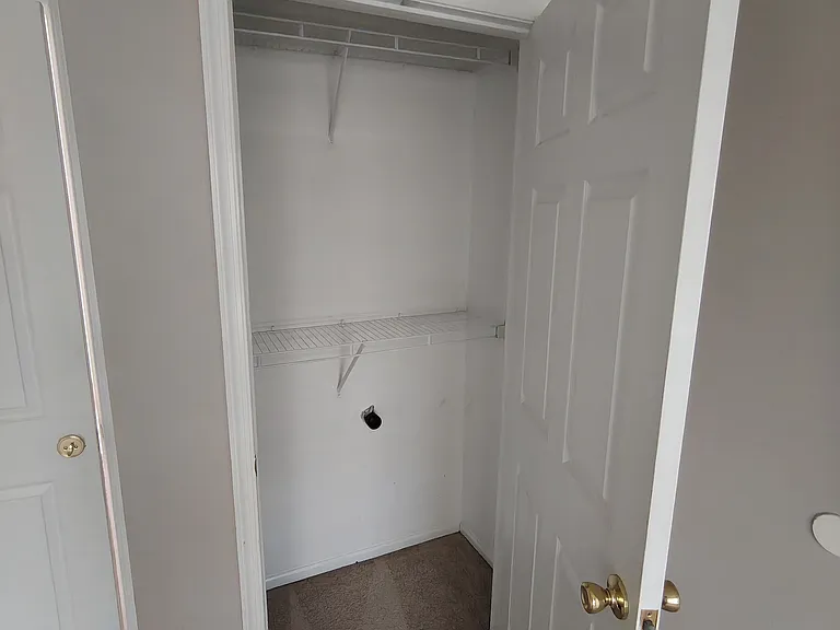 Bedroom features a well_designed attached closet offering ample storage space.