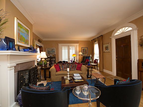 Formal Living Room has large windows, half circle window above door and french door opening to the side porch.