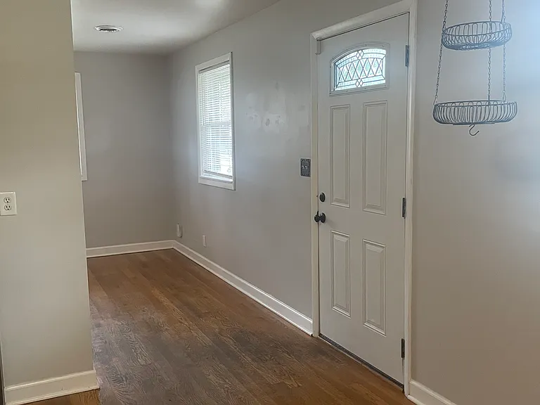 View from the kitchen into the living room. The back door is in between and leads to the to concrete patio.