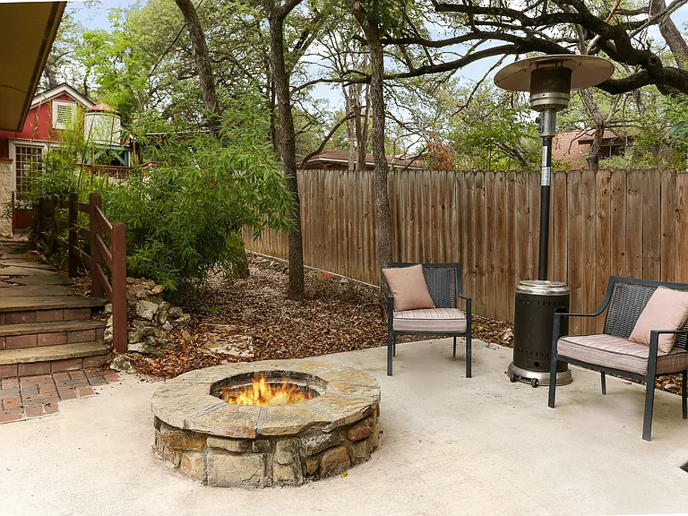 Guest house yard area with built-in fire pit and patio area.