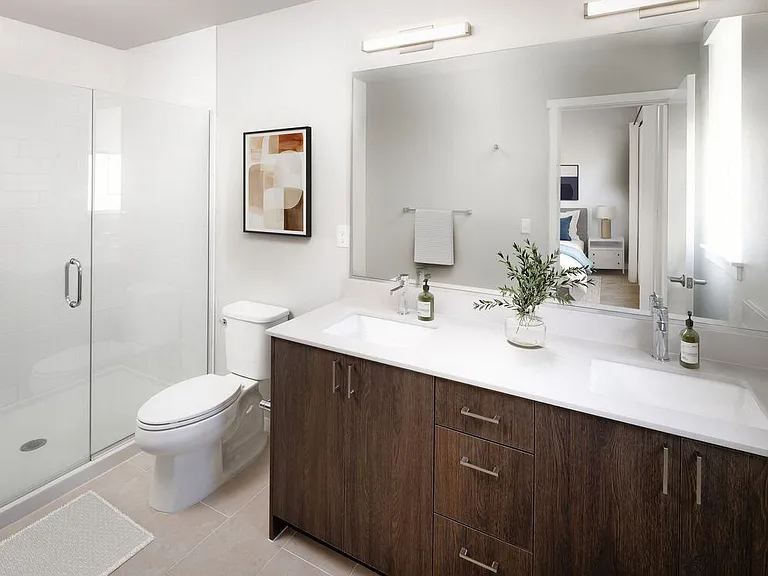 Townhome bath with white quartz countertops, dark cabinetry, and hard surface flooring