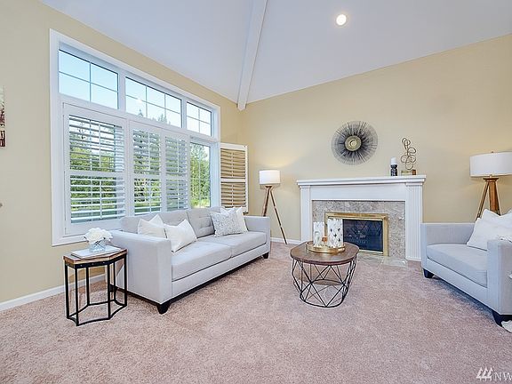 Living room features arched ceilings, wood plantation shutters and a cozy gas fireplace & brand new carpet