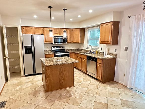 Stainless steel appliances, granite countertops, center island, and a full pantry