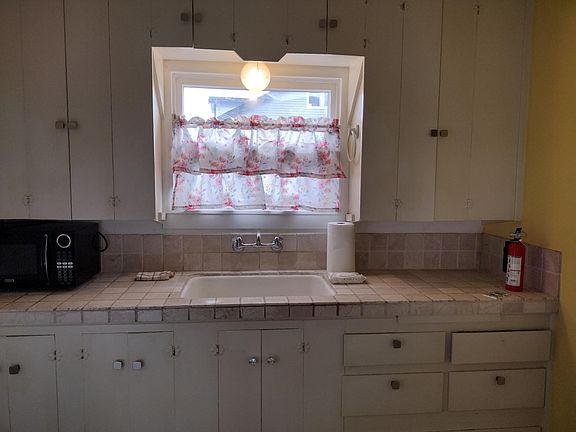 Kitchen has new paint, knobs and curtains.