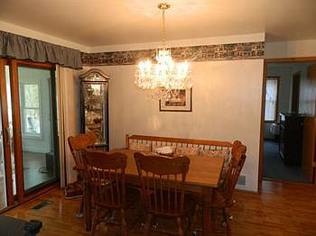 Dining area with slider that leads to a back of the home family room with wood burner.