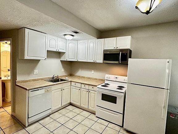 Large Kitchen with Full Appliances including dishwasher , microwave and tile floors.