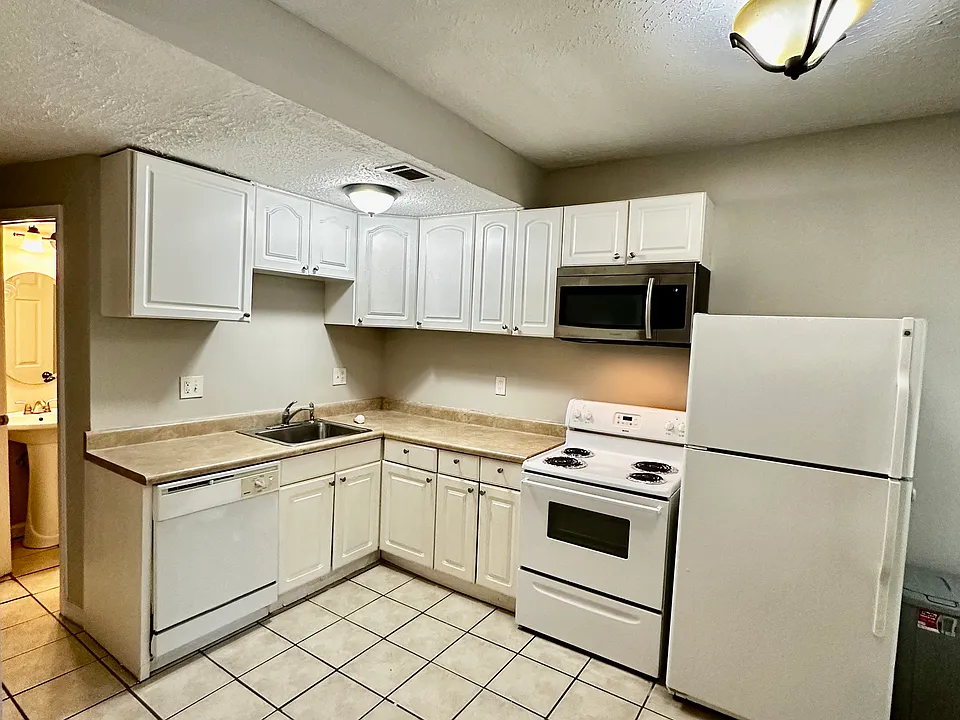 Large Kitchen with Full Appliances including dishwasher , microwave and tile floors.