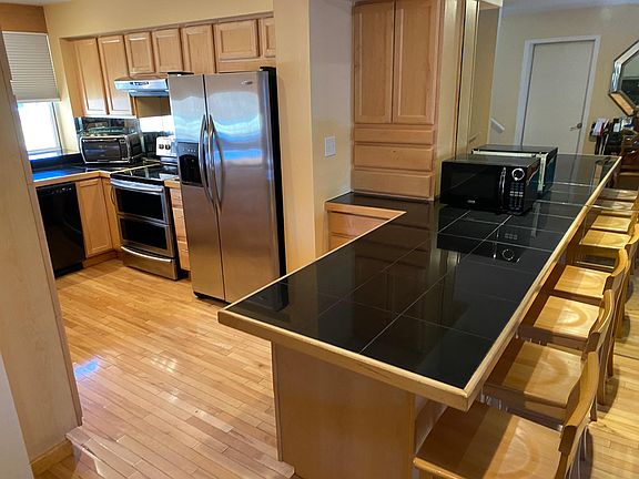 Updated kitchen, with large eat-in bar, lots of smart storage, newer appliances, and wonderful morning sunlight.