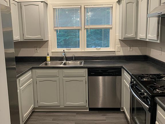 Kitchen with stainless steel appliances, new flooring and countertops
