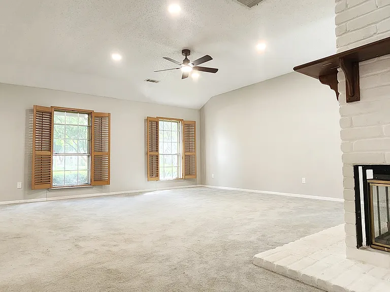Living room with recessed lighting and a featured white and maple brown fireplace