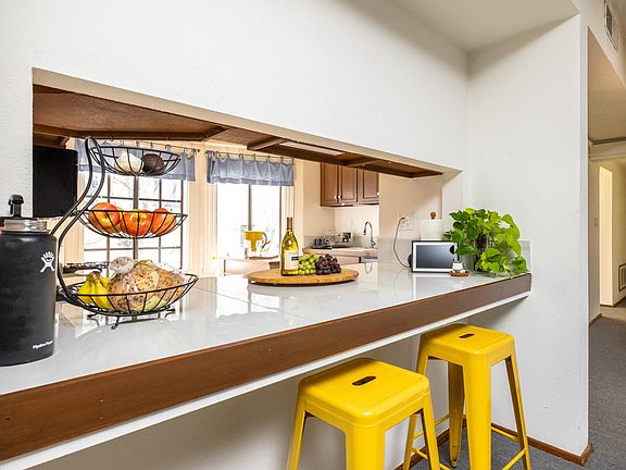Passthrough from kitchen to living room area with breakfast bar.