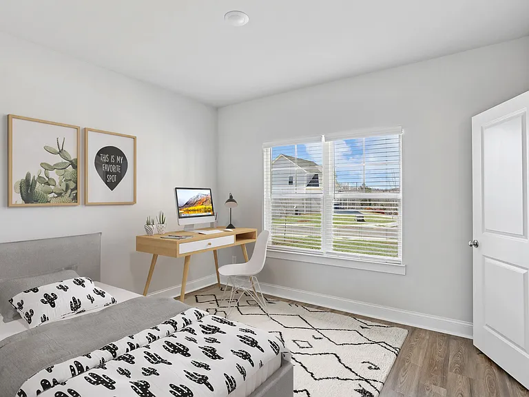 Versatile bedroom featuring a comfortable bed and dedicated workspace.