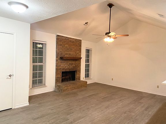 Livingroom with brick fireplace and vaulted ceilings and ceiling fan