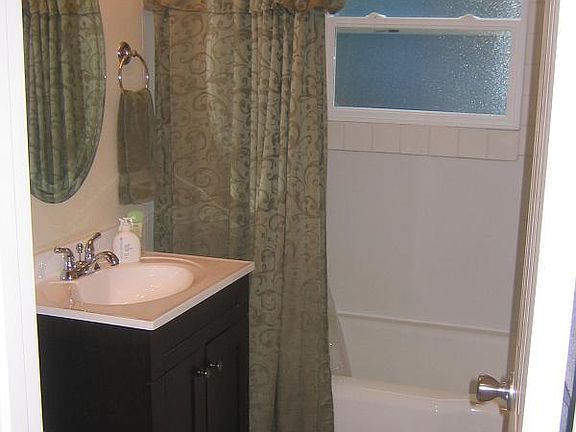 Clean full sized bathroom with bathtub and shower