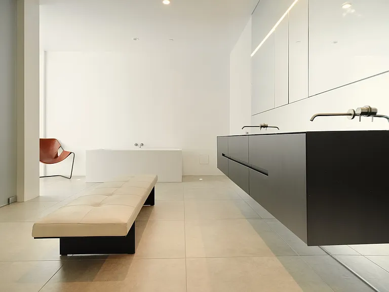 Spa-Inspired Primary Bathroom with Minimalist Design _ This expansive bathroom features a sleek floating double vanity, integrated lighting, and a sculptural soaking tub.