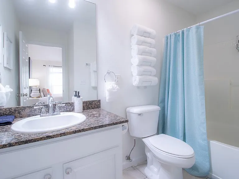 Bath or shower in this serene and luxurious space designed to evoke a sense of relaxation and tranquility, reminiscent of a tropical beach getaway.