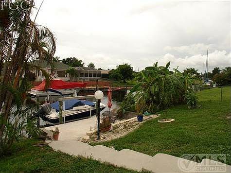 What a set up! Walk down to the large concrete dock to your boat with a 10,000 boat lift included. Seawalled, electric & water at the dock. The canal is deep access with sailboats, large power boats, minutes to the river. Investors know sailboat gulf access without the bridges, locks is where the best investment is! If you can fit the big boat, the canal lot needs to accomodate...as they say the money is in the dirt!