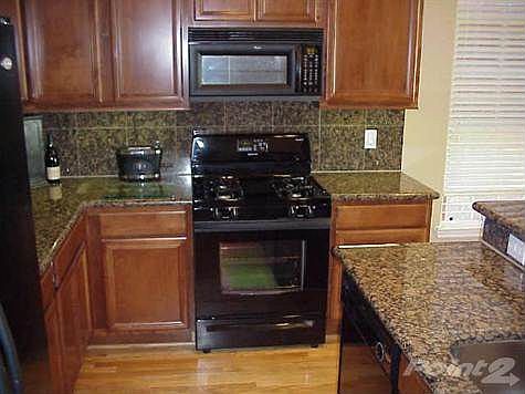 kitchen with granite ciunters and undermount lightings