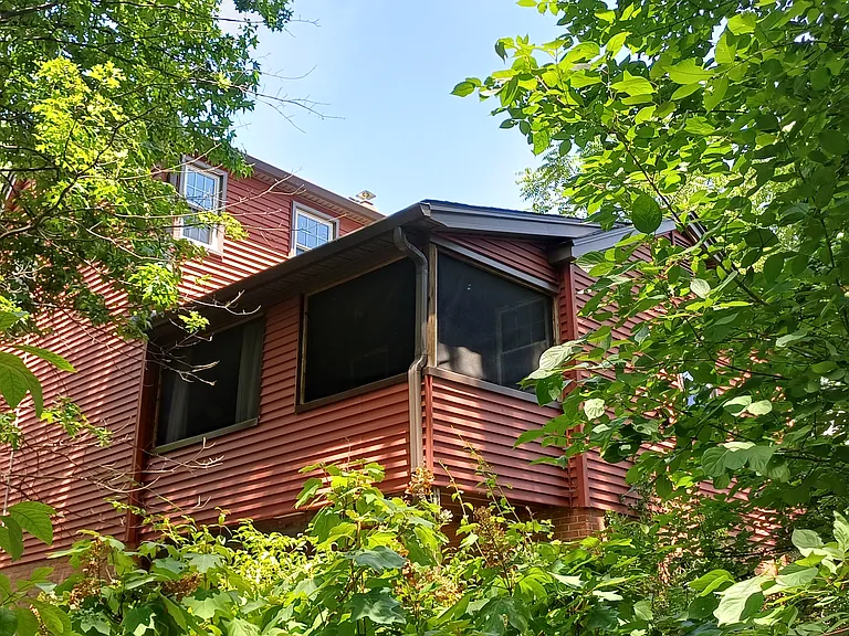 Tree house-level screened porch above separate basement entrance.
