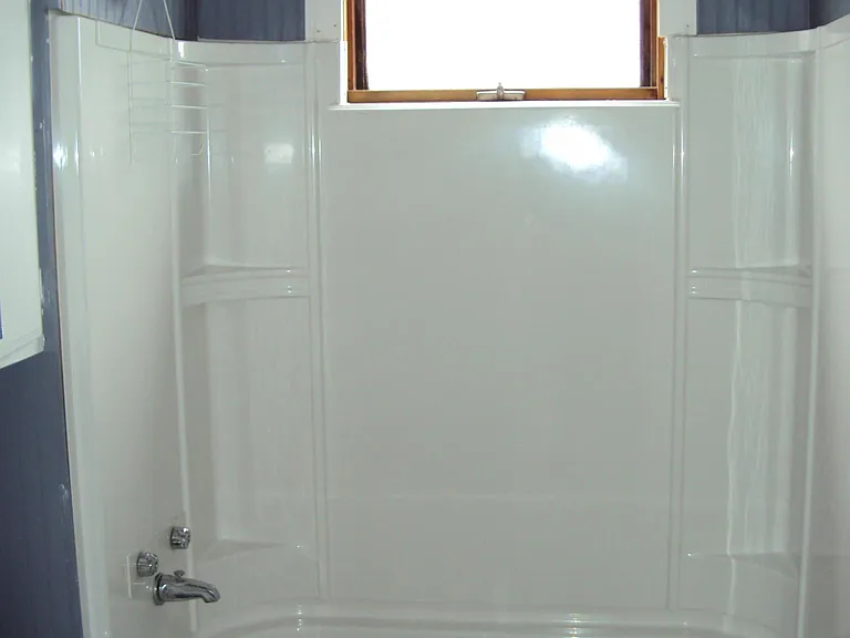 blue and white bathroom with a tiled shower ceiling and a Kohler bathtub surround