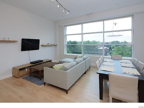 View of living room with 11 foot ceilings, wood floors, huge window (north exposure) being used as a living room/dining room combination.  Dining room currently being used as a den.