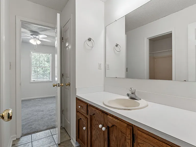 Full bath with dual-access vanity, large mirror, and ample counter space